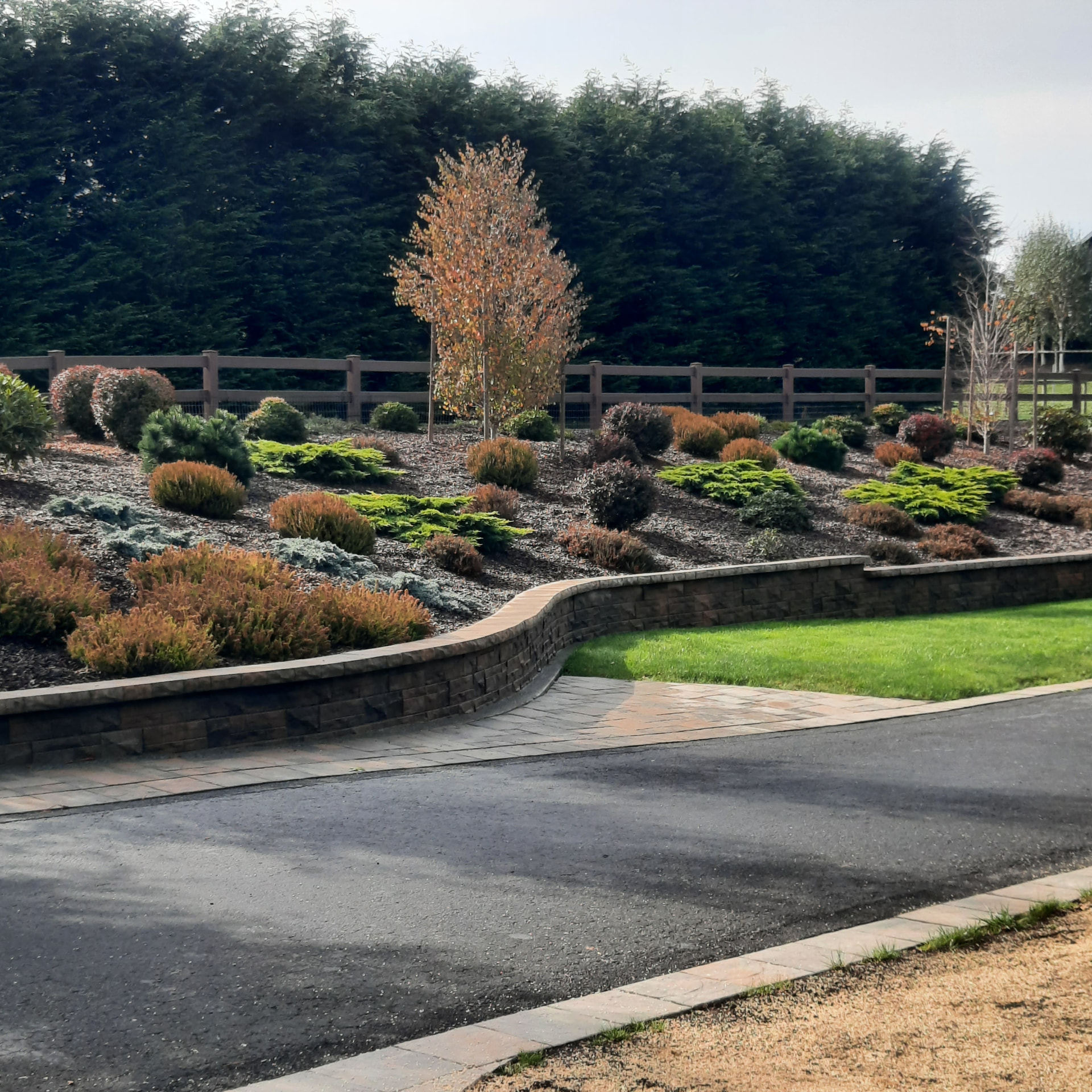 Newly installed hillside landscape with fresh planting beds, mulch, and shaped grade