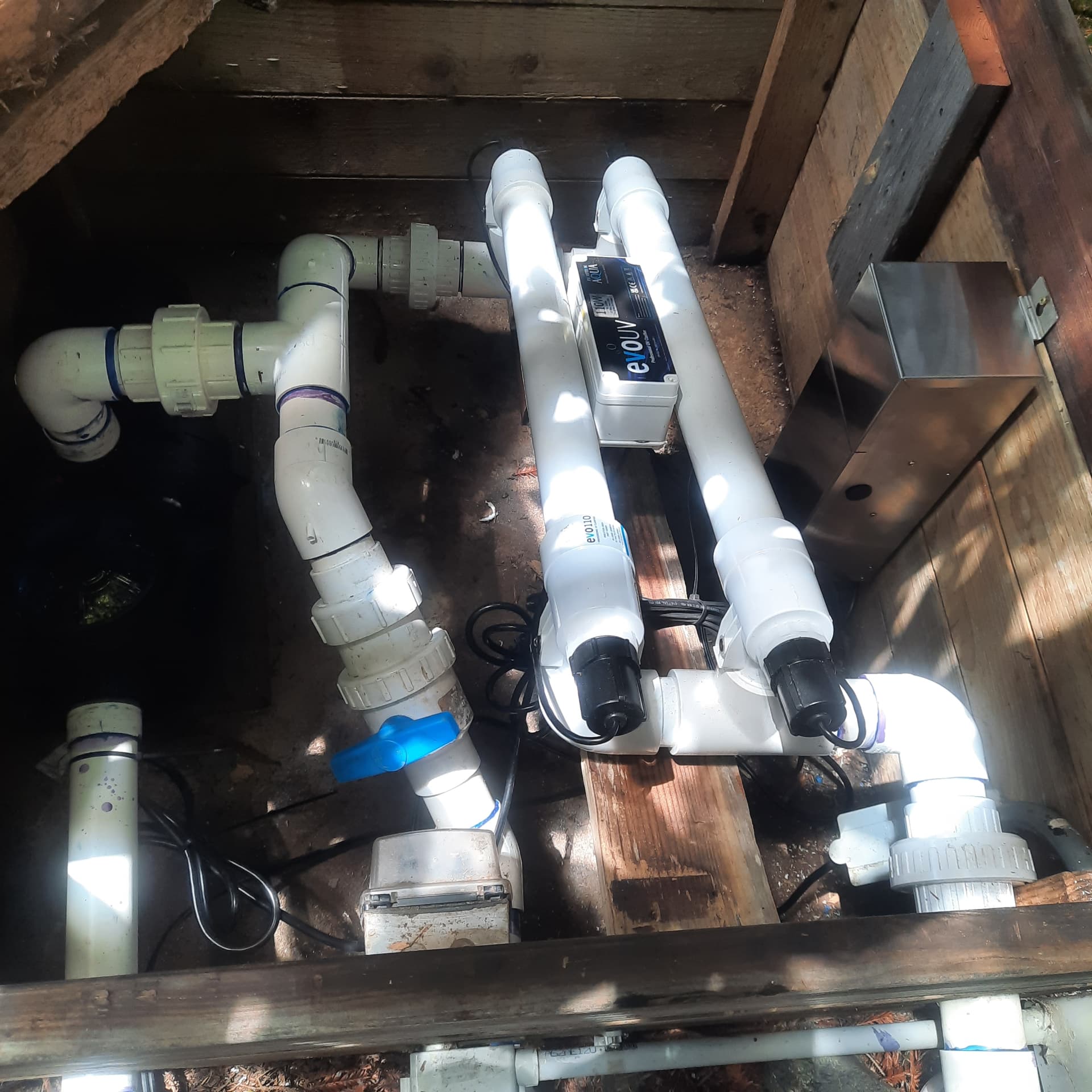 Filtration vault with PVC manifold, valves, UV clarifiers, and pump wiring