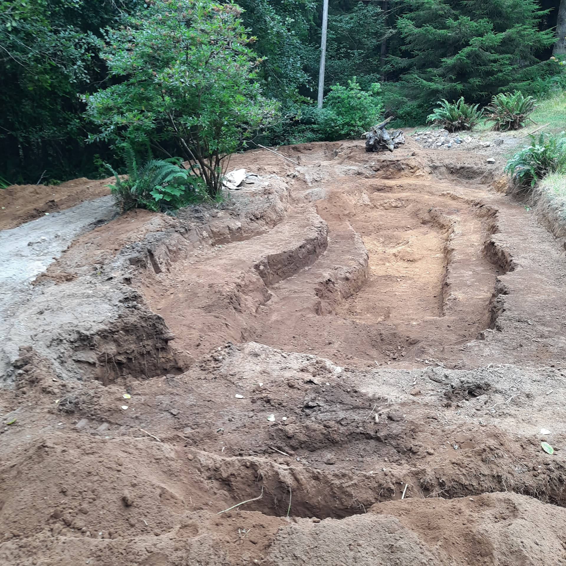 Terraced grading cuts shaped into a sloped property, with clean benches and edges.