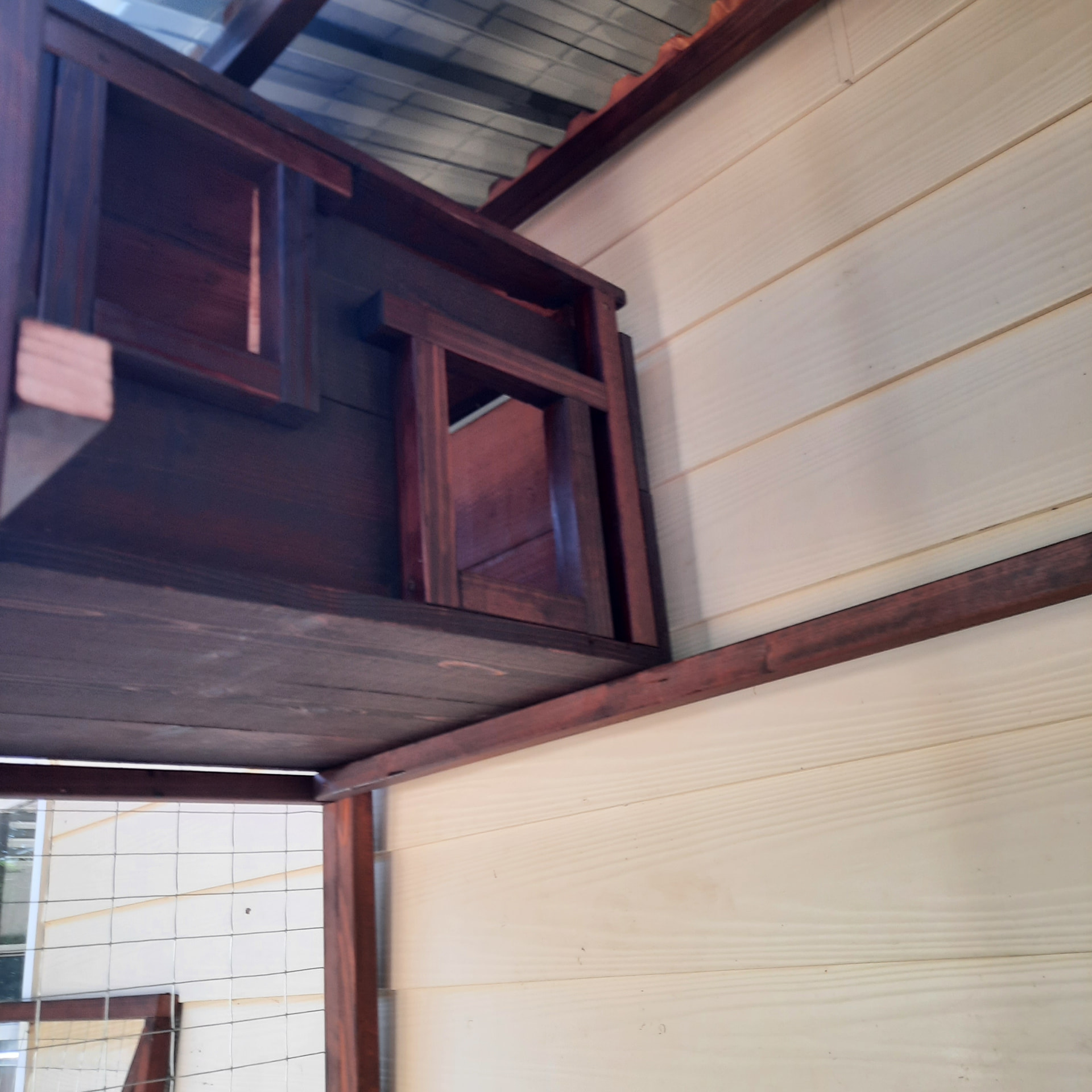 Detail of the stained catwalk framing and roofing where it meets the house siding
