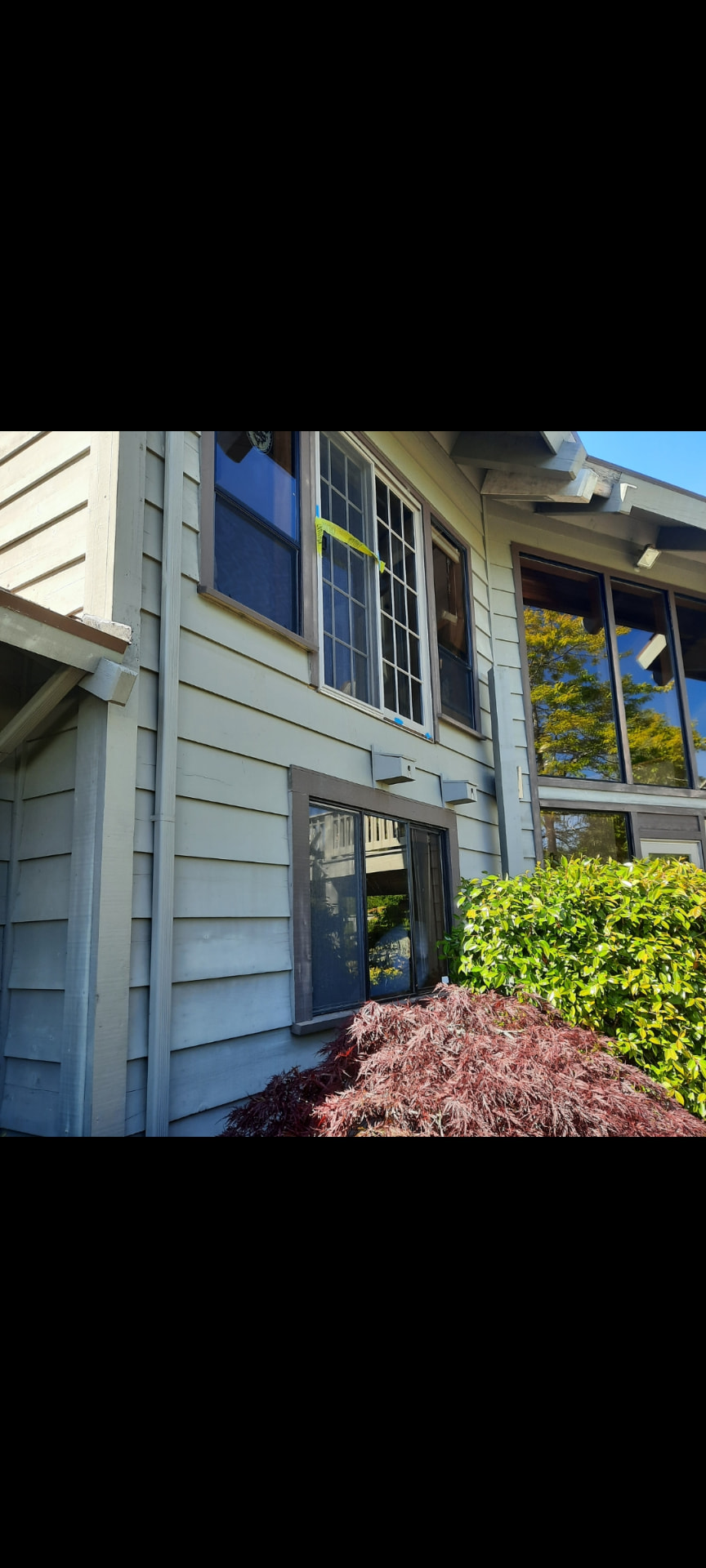 Aging balcony structure during removal, with framing exposed against the house