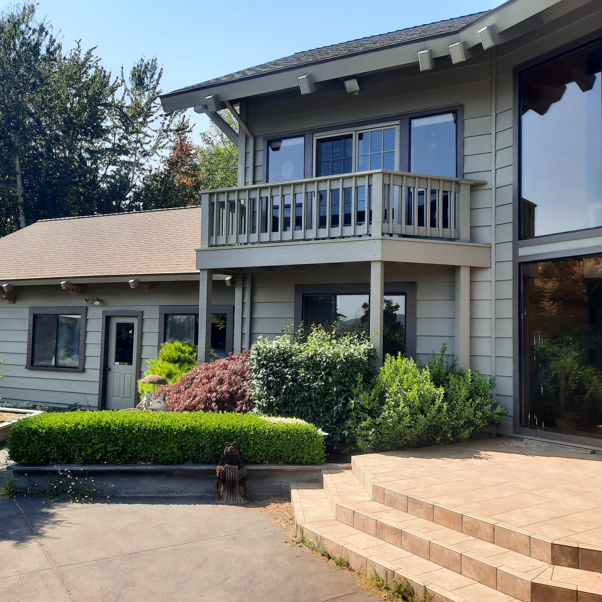 Completed replacement balcony with new railing above the lower entry, matching the house