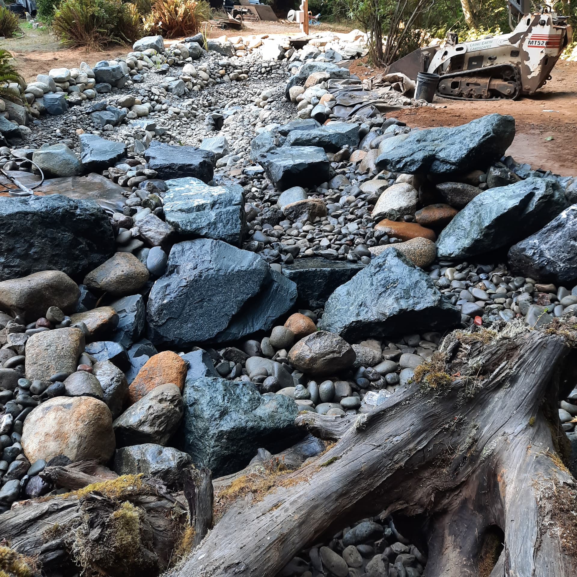 Completed creek and rockwork with the filtration system buried beneath the stone