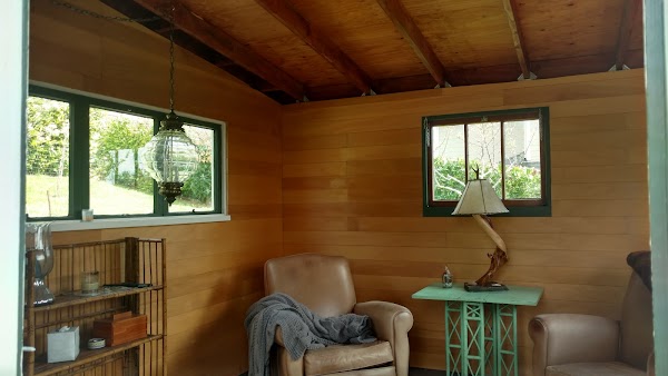Warm finished interior with wood-paneled walls, leather seating, pendant light, and windows