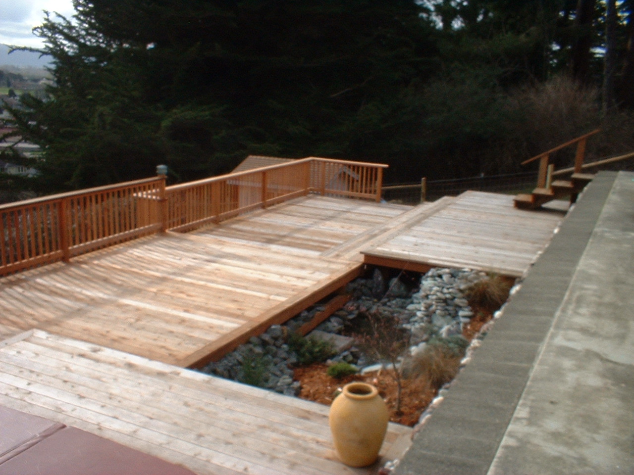 Large wood deck constructed around a small open pond integrated within the deck layout.