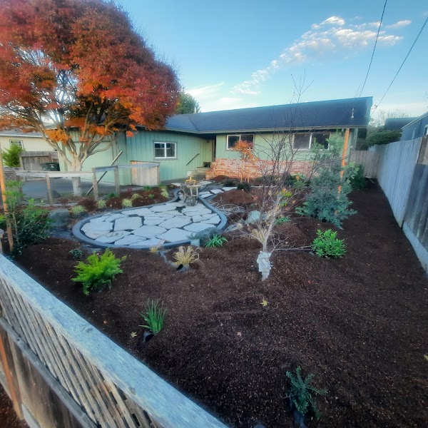 Front-yard renovation with a small patio, layered planting, and a lawn alternative