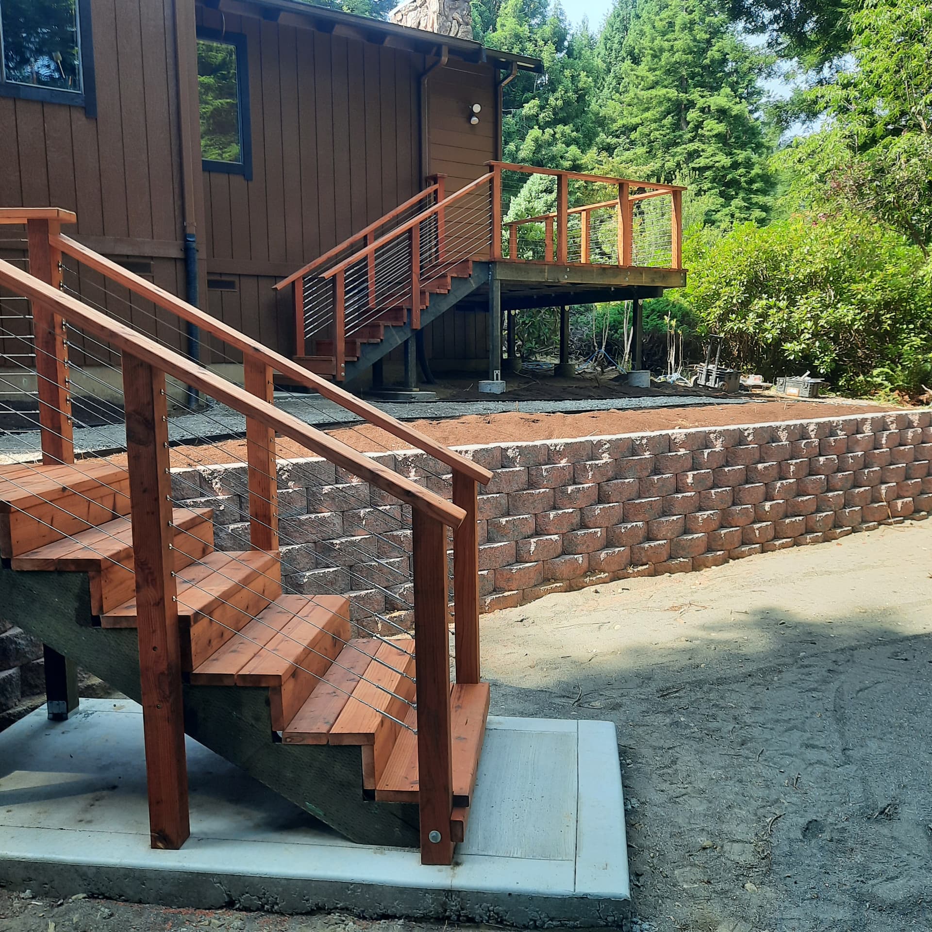 Stone-faced wall meeting timber stairs and decking at a grade transition